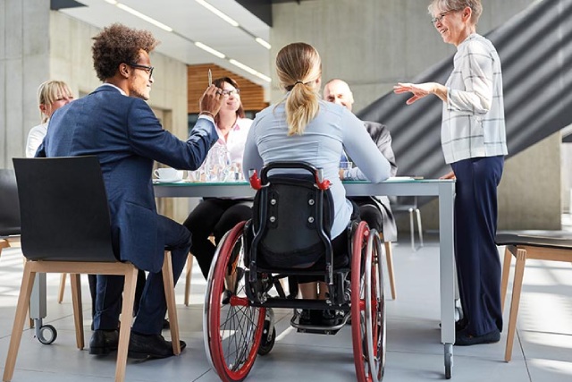 Mujer en silla de ruedas durante una reunión laboral