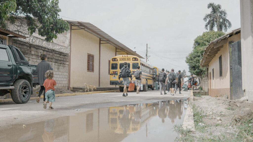 Niñas y niños al lado de un bus escolar
